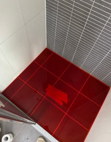 Water testing in a tiled shower during a plumbing investigation
